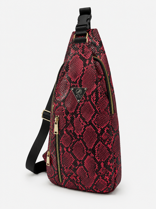 Red snake print sling bag with black accents on a white background