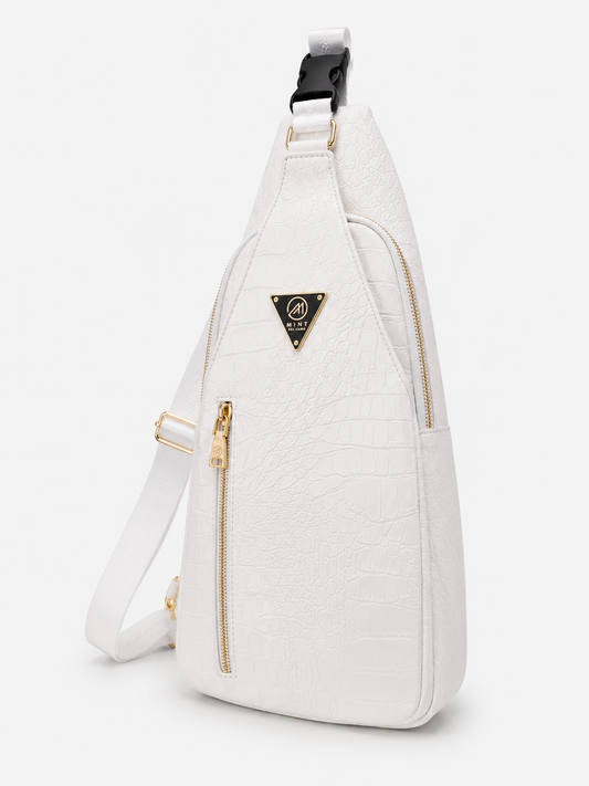 White sling bag with gold zippers on a white background