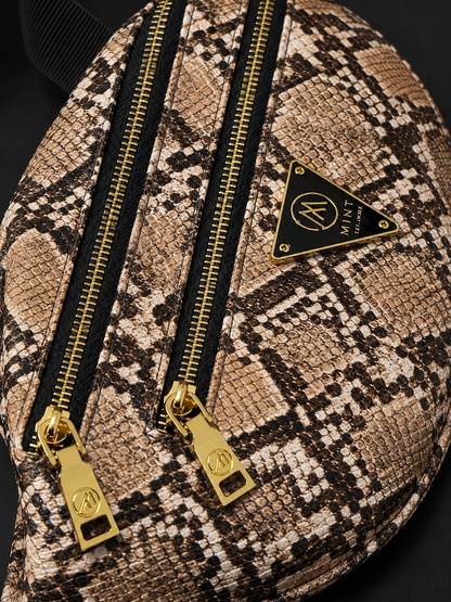 Snakeskin-patterned bag with gold zippers and a brand logo on a dark background